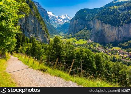 Mountain walking trail from Wengen to village of Lauterbrunnen with the Staubbach Fall, and the Lauterbrunnen Wall in Swiss Alps, Switzerland.. Mountain village Lauterbrunnen, Switzerland