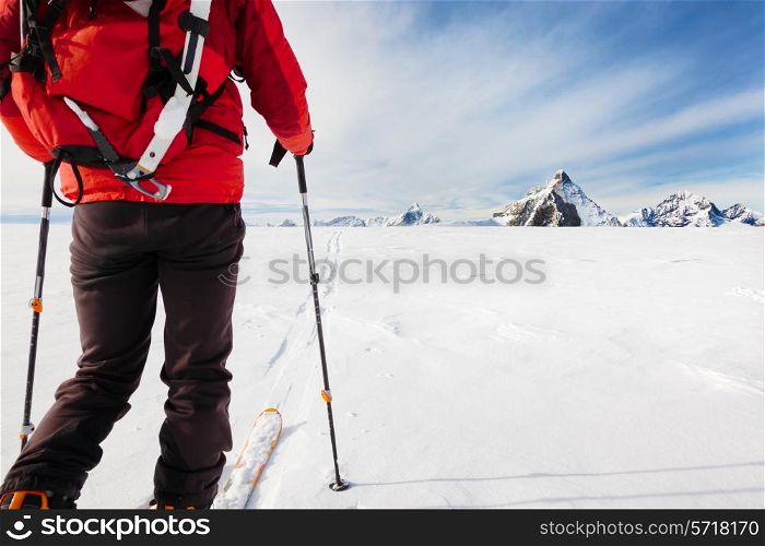 Mountaineer exploring a glacier with the skis during a high-altitude winter expedition in the european Alps. In background the Matterhorn, Zermatt, Switzerland, Europe.
