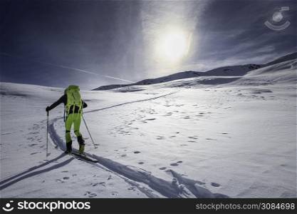 Mountaineer skier alone on a marked slope.