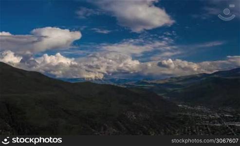 Mountainous landscape panorama view with bold white clouds against a blue sky