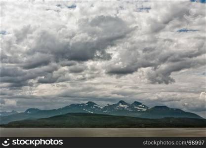 Mountains along the Romsdalsfjorden near Andalsnes under a cloudy sky, Norway. Along the Romsdalsfjorden near Andalsnes, Norway
