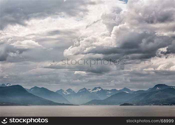 Mountains along the Romsdalsfjorden near Andalsnes under a cloudy sky, Norway. Along the Romsdalsfjorden near Andalsnes, Norway