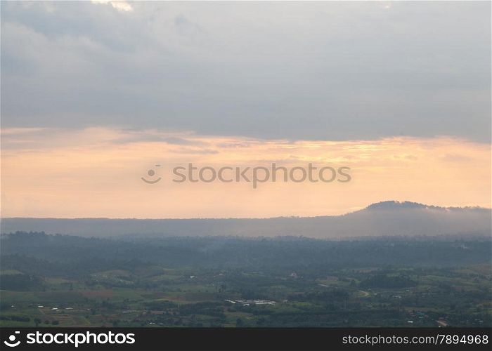 Mountains and forests in the evening. Nearby sun darkens. An agricultural area near the mountains.