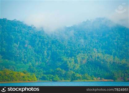 Mountains and forests. The lake in front. Mist-shrouded mountains.