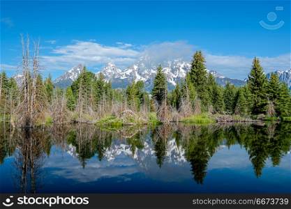Mountains in Grand Teton National Park with reflection in Snake River. Grand Teton Mountains from Schwabacher&rsquo;s Landing on the Snake River at morning. Grand Teton National Park, Wyoming, USA.