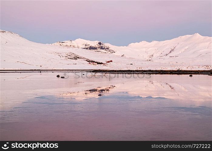 Mountains in Snaefellsnes peninsula reflected in the water at sunset in winter, Iceland. Mountains in Snaefellsnes peninsula at sunset, Iceland