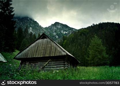 Mountains Landscape. Small wooden house. Nature in wilderness.