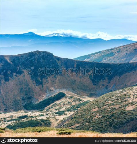 Mountains landscape with field of dry grass and blue sky. Mountains landscape with field of grass