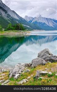 Mountains reflecting in Medicine Lake in Jasper National Park, Canada