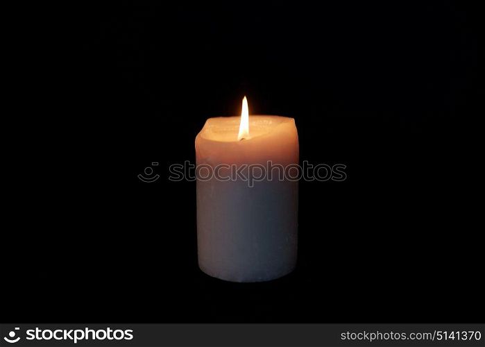 mourning and commemoration concept - candle burning in darkness over black background. candle burning in darkness over black background