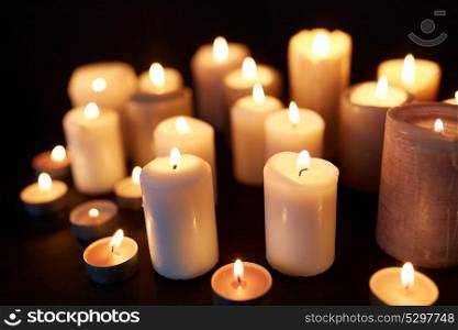 mourning and commemoration concept - candles burning in darkness over black background. candles burning in darkness over black background