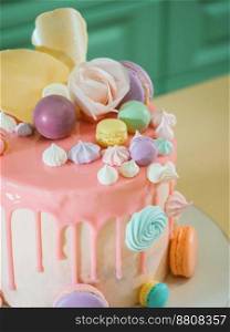 Mousse cake covered with pink chocolate velvet and mirror glaze, decorated with meringues, macaroons and roses