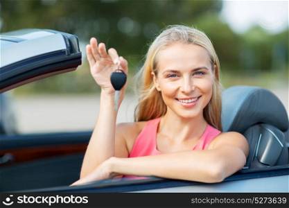 movable property, security and transport concept - happy young woman with convertible car key. happy young woman with convertible car key