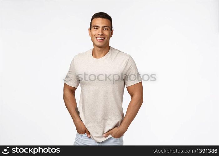 Movember, people concept. Handsome male athlete in casual t-shirt, hold hands in pockets and smiling with happy, pleased expression, standing modest over white background promote advertise.. Movember, people concept. Handsome male athlete in casual t-shirt, hold hands in pockets and smiling with happy, pleased expression, standing modest over white background promote advertise