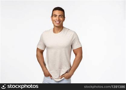 Movember, people concept. Handsome male athlete in casual t-shirt, hold hands in pockets and smiling with happy, pleased expression, standing modest over white background promote advertise.. Movember, people concept. Handsome male athlete in casual t-shirt, hold hands in pockets and smiling with happy, pleased expression, standing modest over white background promote advertise