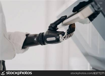 Moves and touches of robotic cyber hand. Disabled person going to cook in oven. Amputee using high technology bionic prosthesis. Software in fingers and wrist joint. Rehabilitation technology concept.. Moves and touches of robotic cyber hand. Disabled person going to cook in oven.