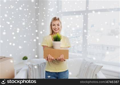 moving, delivery, accommodation and people concept - smiling young woman with cardboard box and plant at home over snow