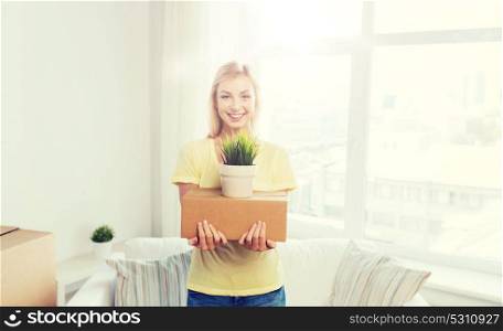 moving, delivery, accommodation and people concept - smiling young woman with cardboard box at home. smiling young woman with cardboard box at home