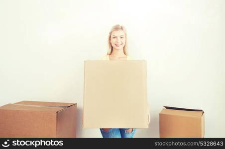 moving, delivery, housing, accommodation and people concept - smiling young woman with cardboard box at home. smiling young woman with cardboard box at home