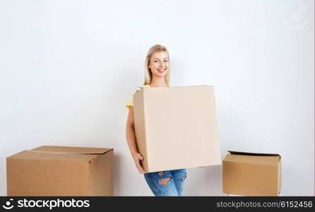 moving, delivery, housing, accommodation and people concept - smiling young woman with cardboard box at home