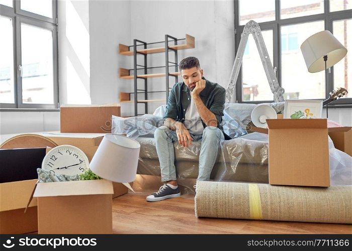 moving, eviction and real estate concept - sad man with boxes at new home. sad man with boxes moving to new home