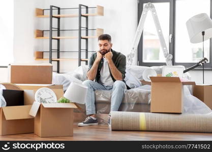 moving, eviction and real estate concept - sad man with boxes at new home. sad man with boxes moving to new home