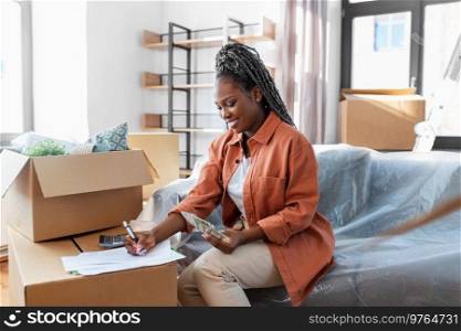 moving, finances and real estate concept - happy smiling woman with money, bills and calculator at new home. happy woman moving to new home and counting money
