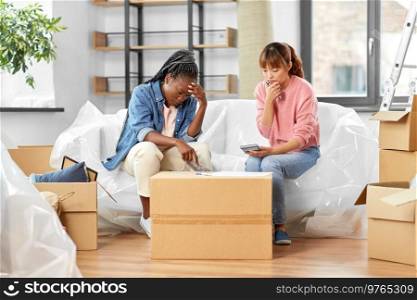 moving, finances and real estate concept - women with money, bills and calculator at new home. women moving to new home and counting money