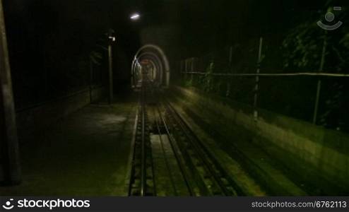 Moving funicular in subway tunnel, cabin view