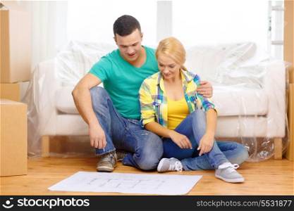 moving, home and couple concept - smiling couple relaxing on sofa and looking at blueprint in new home