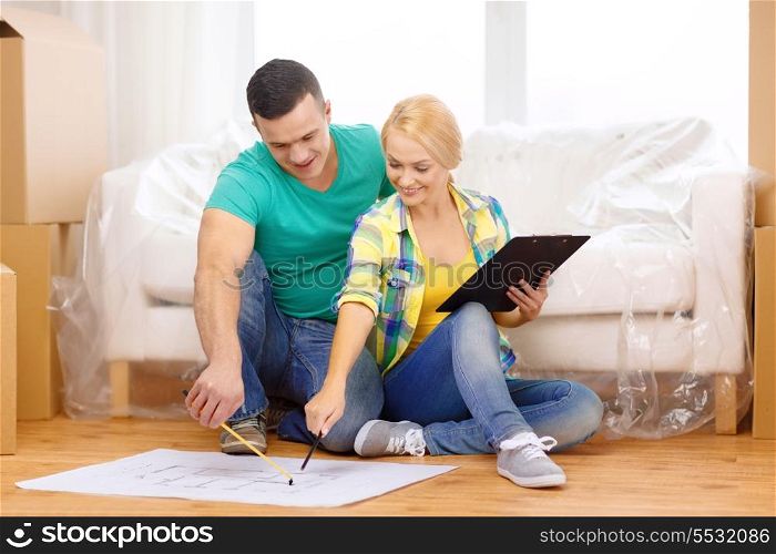 moving, home and couple concept - smiling couple relaxing on sofa and looking at blueprint in new home