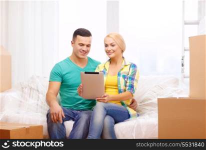moving, home, technology and couple concept - smiling couple relaxing on sofa with tablet pc computer in new home