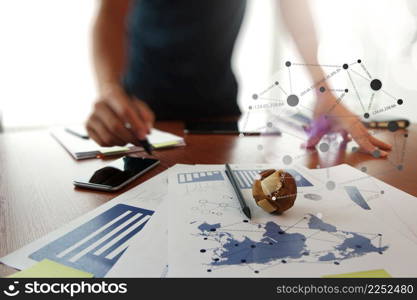 Moving Image of Business creative designer working wooden texture globe with smart phone on business document in office desk as internet concept