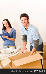 Moving new home young happy couple unpacking cardboard boxes together