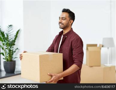 moving, people and real estate concept - happy indian man with boxes at new home. happy man with box moving to new home