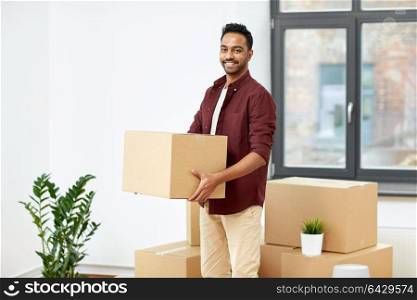 moving, people and real estate concept - happy indian man with boxes at new home. happy man with box moving to new home