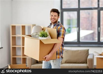 moving, people and real estate concept - happy man with boxes at new home. happy man with box moving to new home