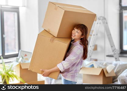 moving, people and real estate concept - happy smiling asian woman holding big boxes with stuff at new home. happy woman holding boxes and moving to new home