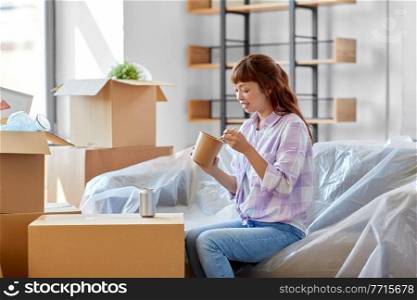 moving, people and real estate concept - happy smiling asian woman with boxes eating takeaway chinese food at new home. happy woman moving to new home and eating wok