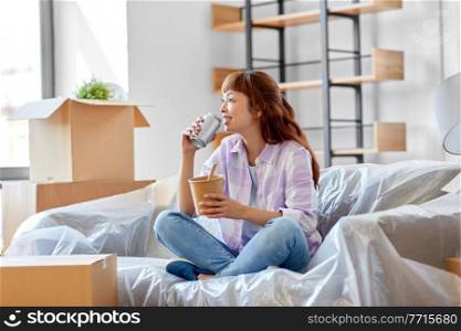 moving, people and real estate concept - happy smiling asian woman with boxes eating takeaway chinese food and drinking from tin can at new home. happy woman moving to new home and eating wok