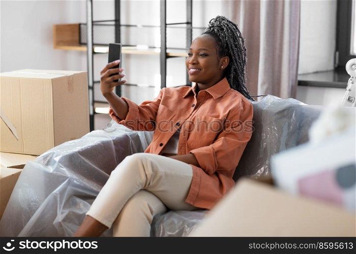 moving, people and real estate concept - happy smiling asian woman with smartphone taking selfie at new home. woman with smartphone taking selfie at new home