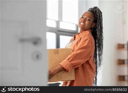 moving, people and real estate concept - happy smiling woman holding box at new home. happy woman with boxe moving to new home