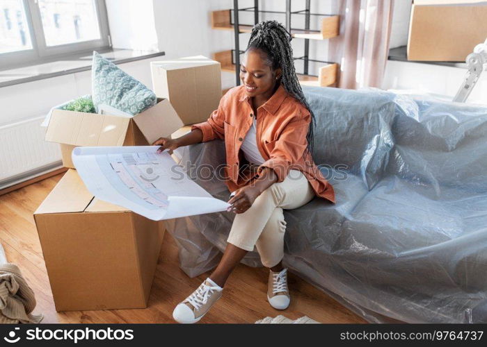 moving, people and real estate concept - happy smiling woman with blueprint and boxes at new home. woman with blueprint and boxes moving to new home