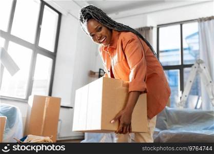 moving, people and real estate concept - happy smiling woman with boxes at new home. happy woman with boxes moving to new home