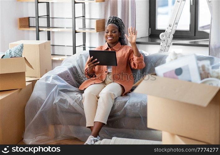moving, people and real estate concept - happy smiling woman with tablet pc computer having video call at new home. smiling woman with tablet pc having video call