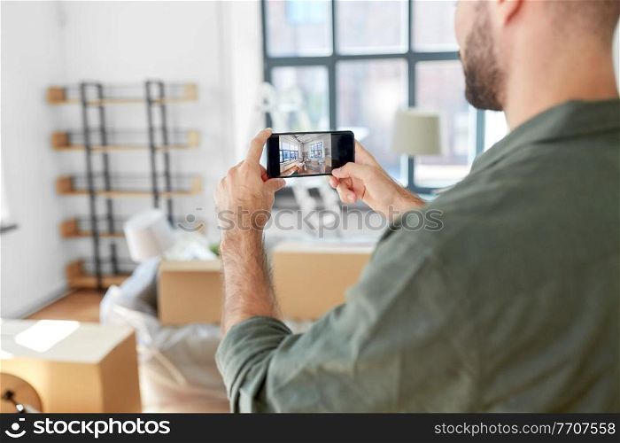 moving, people and real estate concept - man with smartphone taking picture of new home. man with smartphone taking picture of new home