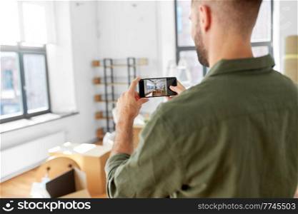 moving, people and real estate concept - man with smartphone taking picture of new home. man with smartphone taking picture of new home