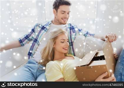 moving, people, delivery and mail concept - happy couple with cardboard box or parcel at home