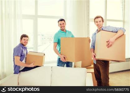 moving, real estate and friendship concept - smiling male friends carrying boxes at new place