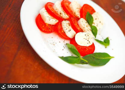 Mozzarella cheese tomato and basil on a plate